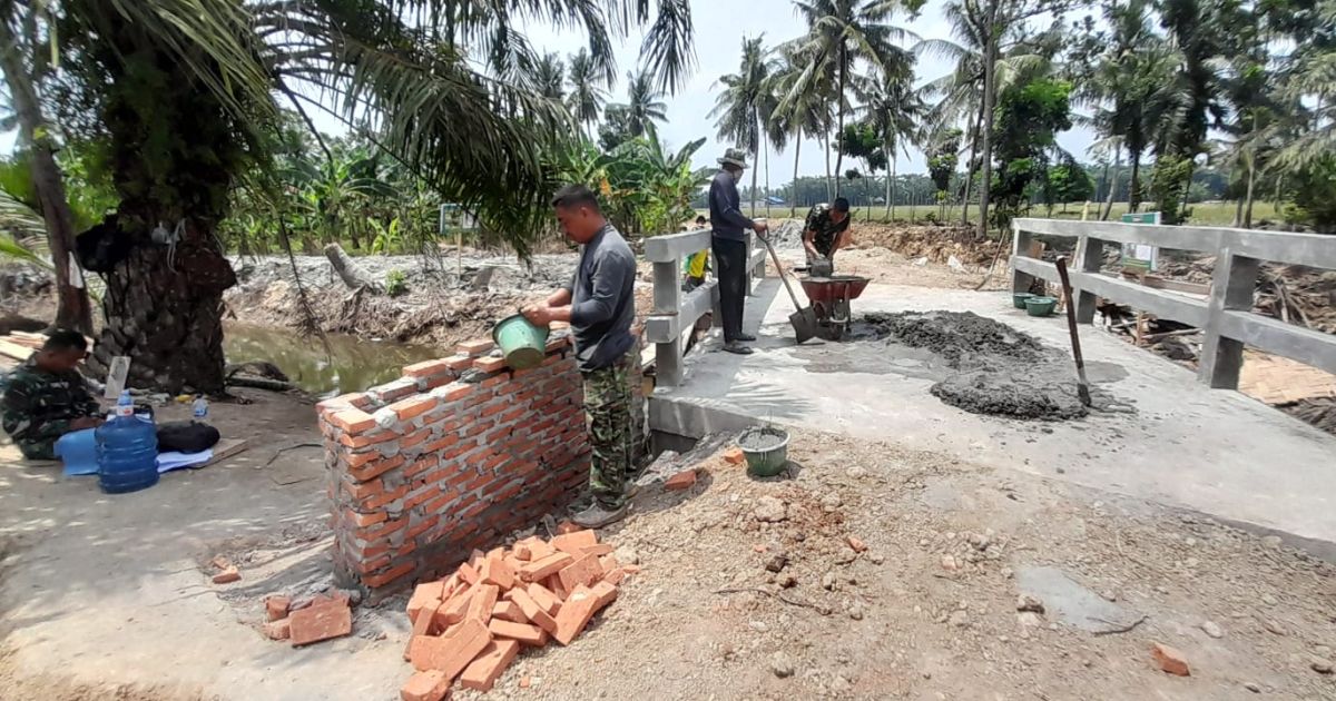 Senyum Semangat Satgas Warnai Pembangunan Jembatan Desa Pasar Rawa